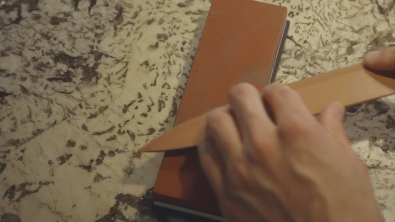 afilar el cuchillo de cocina con piedra afilada - de cerca