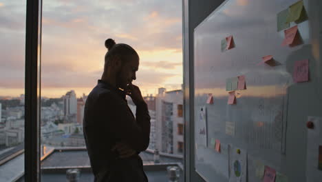 Mannsilhouette-Grübelt-über-Whiteboard-In-Der-Sunset-Hall,-Nahaufnahme.-Entwickler-Arbeitet