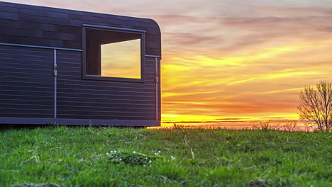 Toma-Cinematográfica-Del-Sol-Saliendo-Desde-Detrás-De-Una-Cabaña-De-Madera-En-El-Campo-Rural-En-Timelapse