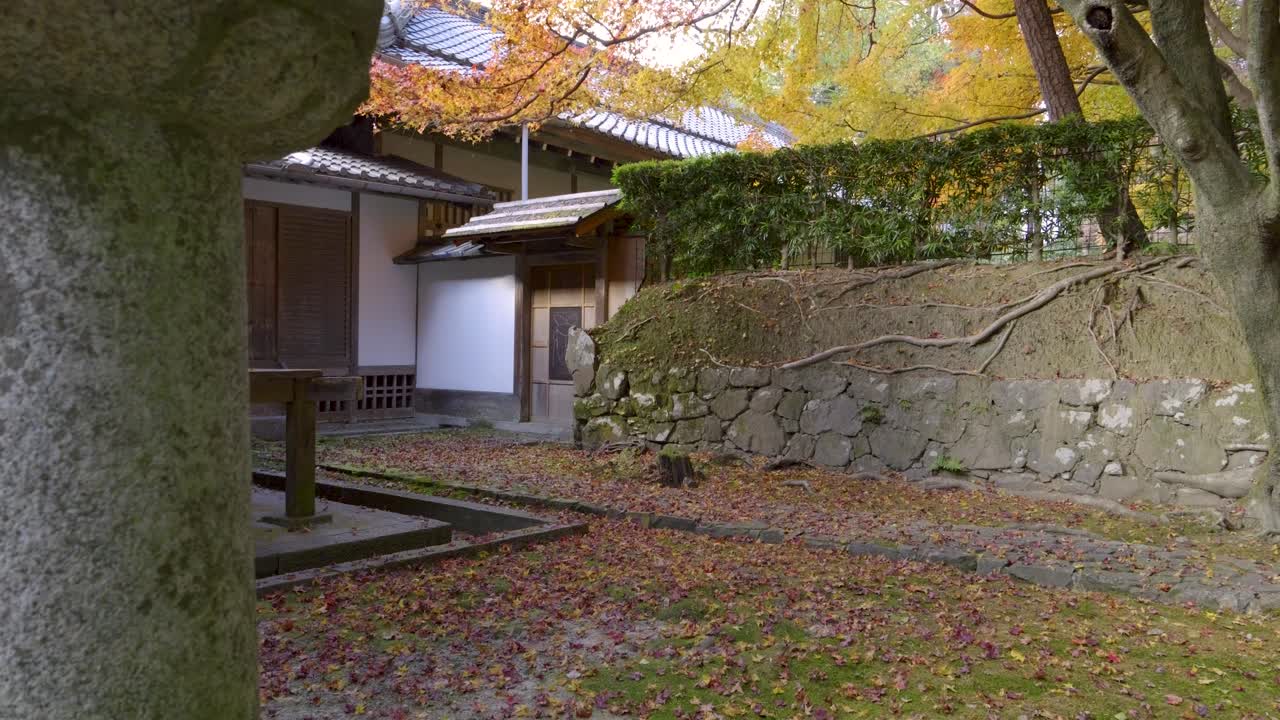 impresionante deslizador en cámara lenta revela sobre los terrenos del templo con hojas de color de otoño caídas