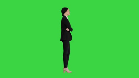 confident young businesswoman posing with crossed arms on a green screen, chroma key