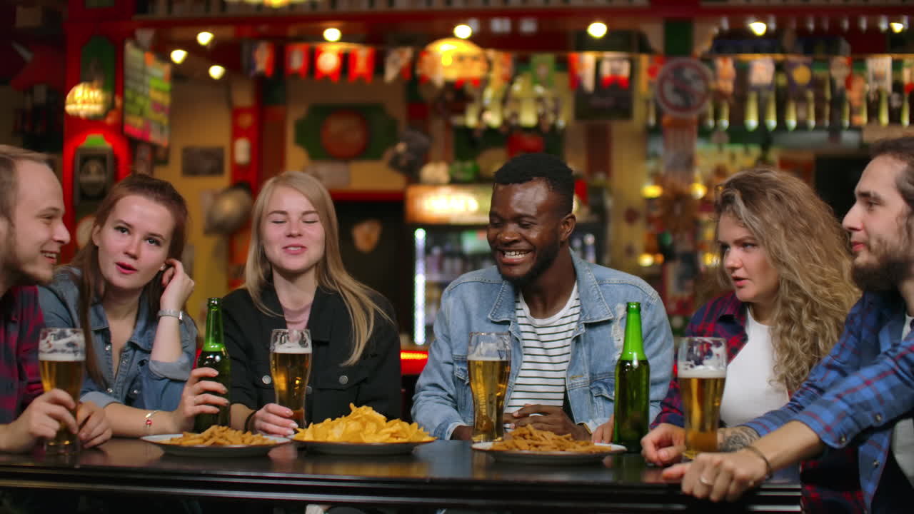 in compagnia di amici divertenti di stranieri e donne studenti ridono discutere storie divertenti e pettegolezzi.