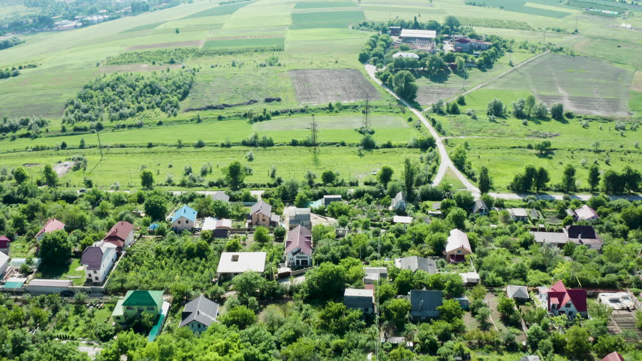 Aerial View of a Village with Houses and Green Fields