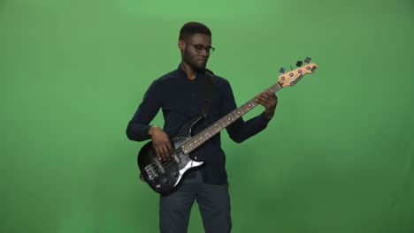man playing bass guitar on green screen