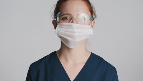 Redheaded-doctor-in-front-of-camera-on-gray-background.