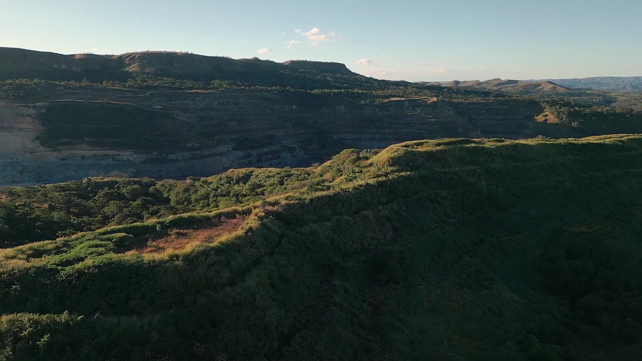 Paesaggio di scarpata sopra un'area di estrazione di calcare a Fercal, Brasília, Distretto Federale, Brasile, con vegetazione del Cerrado e terrazzamenti di cava esposti, catturato in un'ampia ripresa aerea con drone.