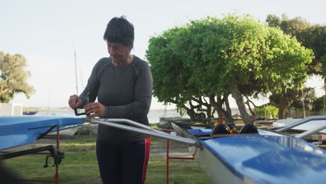 Senior-caucasian-woman-preparing-rowing-boat-for-the-water