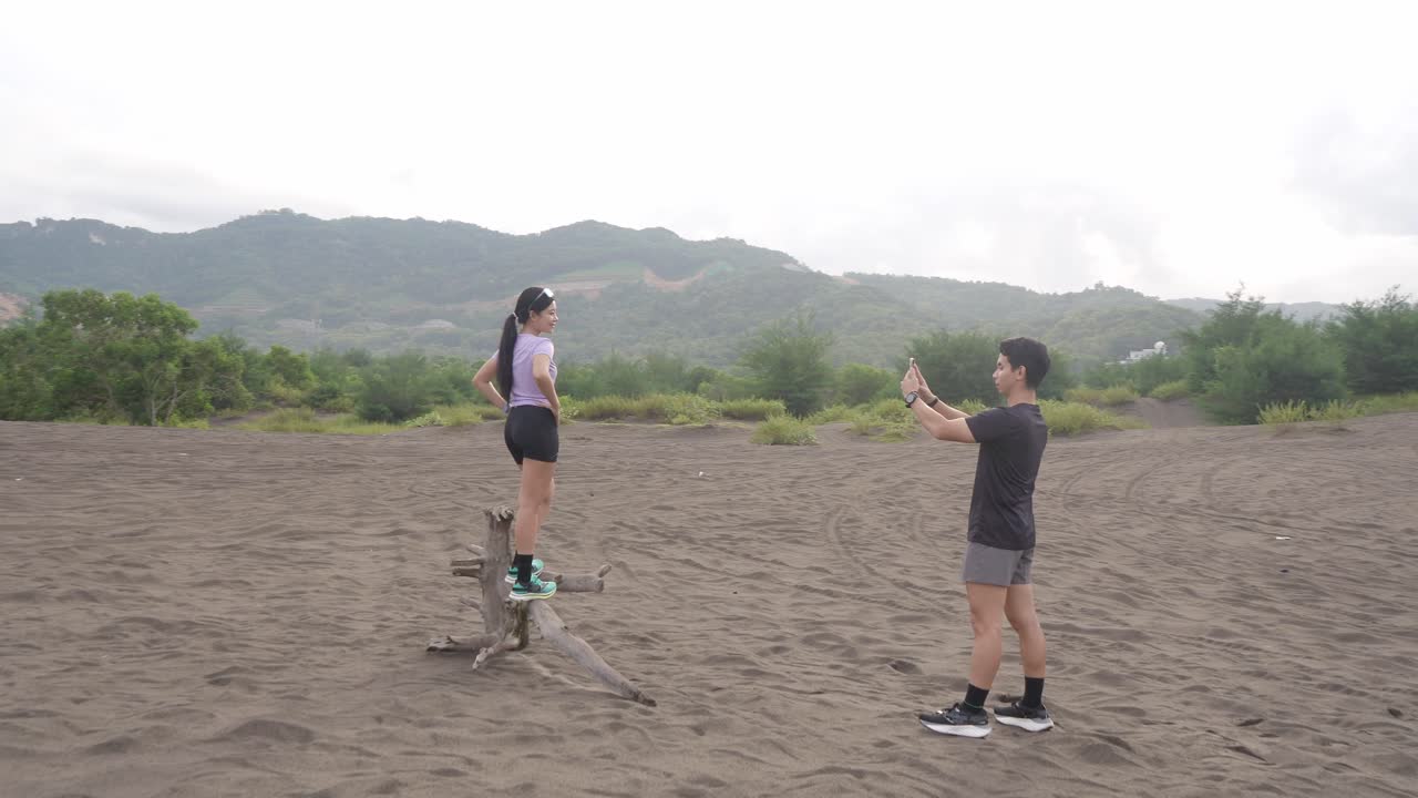 Couple taking photos at scenic sand dunes