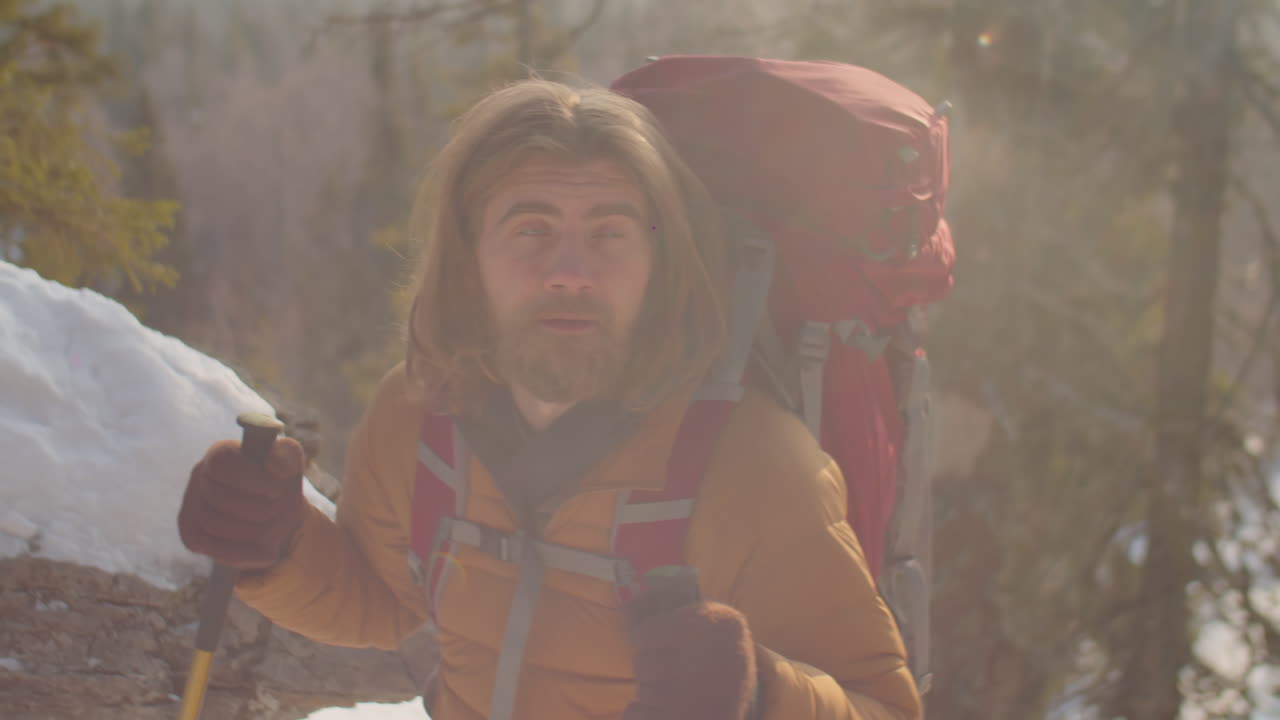 Tourist Climbing Mountain Trail with Hiking Poles and Enjoying View