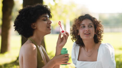mujeres soplando burbujas al aire libre