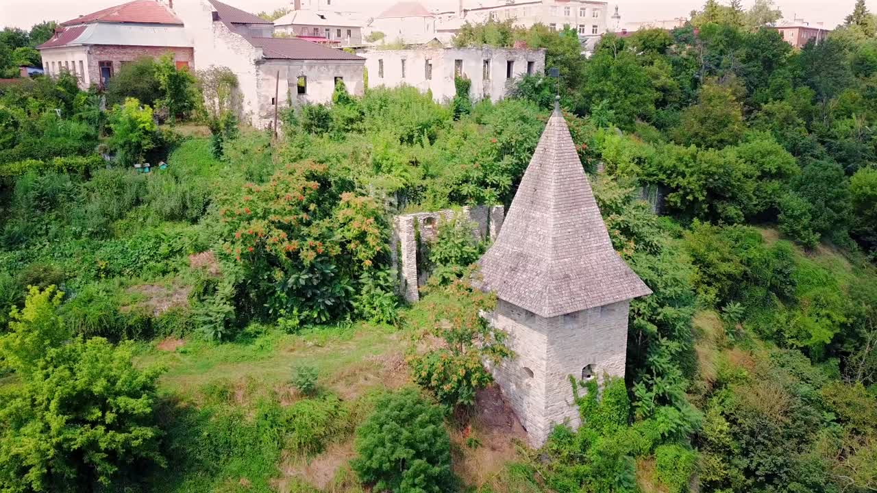 Beautiful aerial Circle pan of Kushnirska Tower surrounded with greenery and old buildings at Kamianets Podilski,Ukraine.