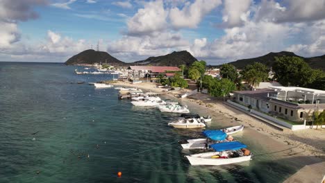 tropical island beach with boats and houses