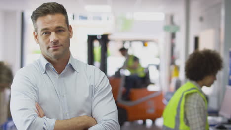 retrato de un gerente masculino sonriente en un almacén de distribución de logística ocupado