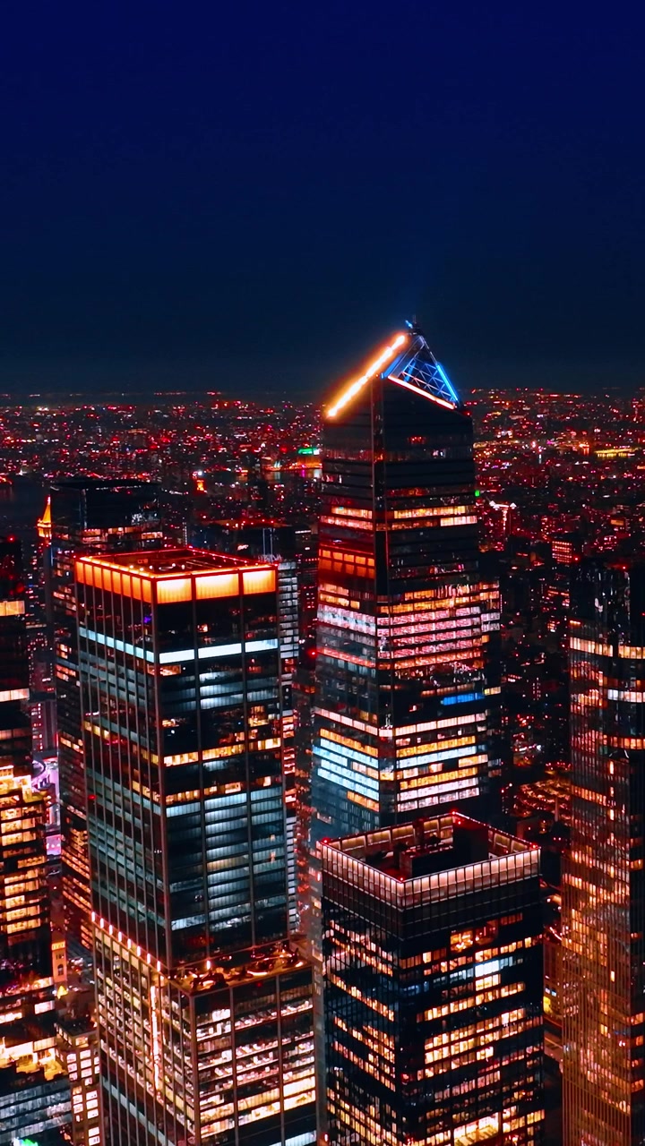Elevando-se sobre o centro da deslumbrante Nova York à noite. Vista esplêndida da metrópole americana com iluminação incrível. Vídeo vertical.