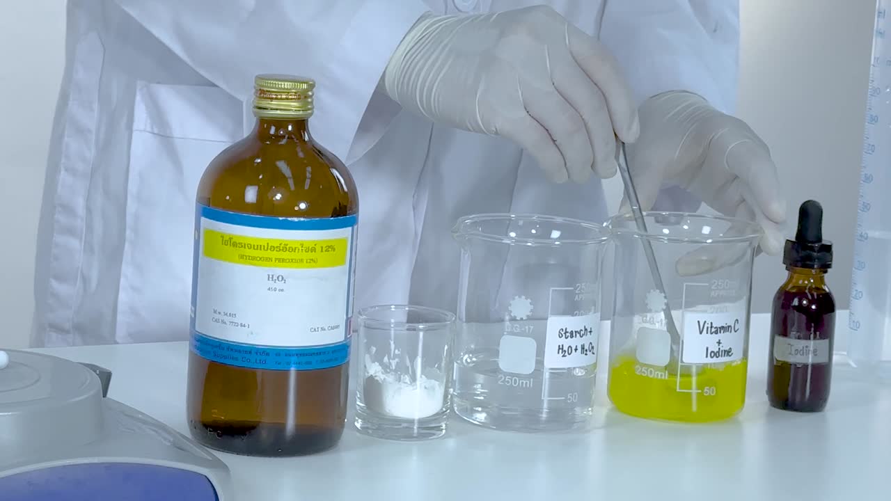 A scientist mixes vitamin C and starch solutions, observing changes in a laboratory setting.