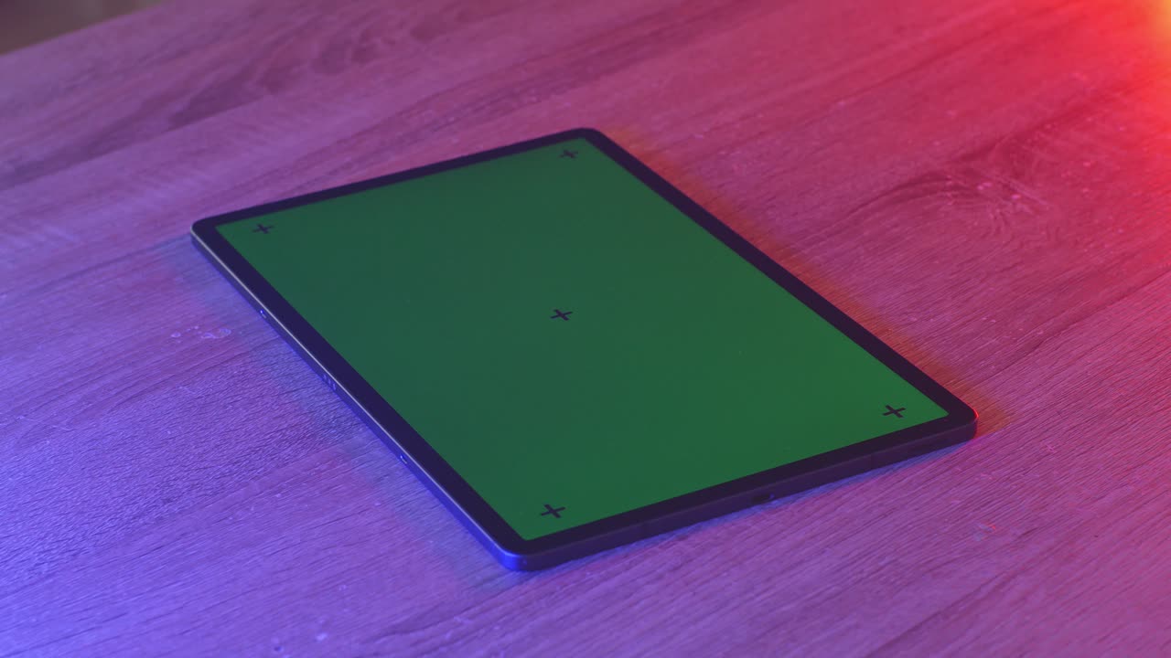 tableta con pantalla verde en una mesa de madera