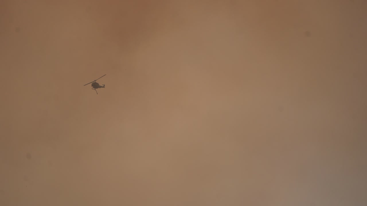 helicóptero volando hacia la puesta del sol hd