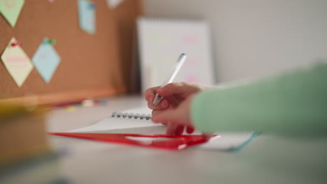 girl draws geometrical figure with triangular ruler at desk