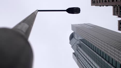 looking up at lamppost and skyscrapers