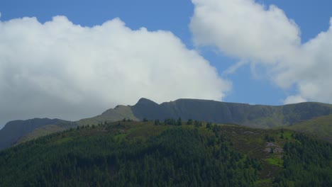 Weiße-Wolken,-Die-Im-Sommer-Schnell-über-Berggipfeln-Aufsteigen,-Vor-Denen-Sich-Kiefernwälder-Befinden