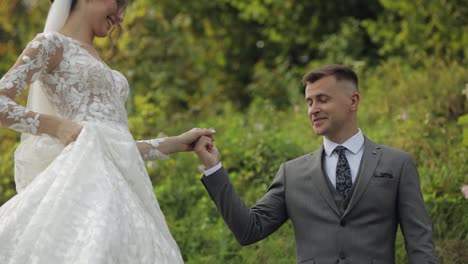 Lovely-newlyweds-caucasian-bride-groom-walking-in-park,-holding-hands,-wedding-couple-family