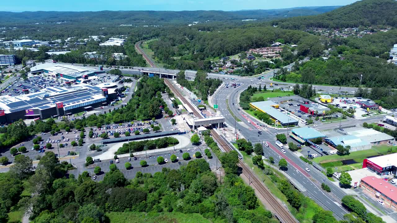 Drone aerial landscape of Tuggerah train station platform and bridge overpass cars driving on main road street highway Central Coast Australia urban infrastructure travel transport