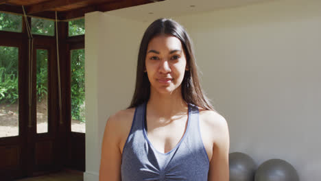 Portrait-of-smiling-asian-female-yoga-instructor-in-sunny-garden