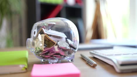 Piggy bank with money on a wooden table