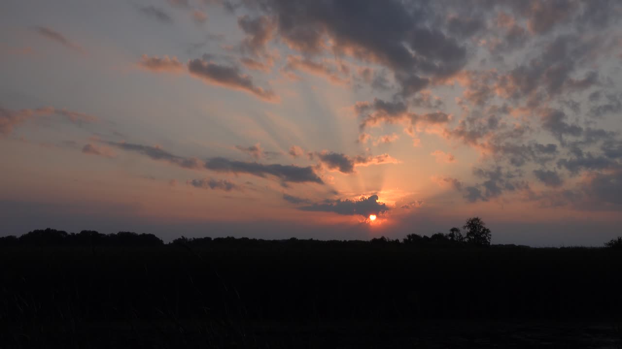 Dramatic Sunset with Crepuscular Rays and Silhouetted Landscape