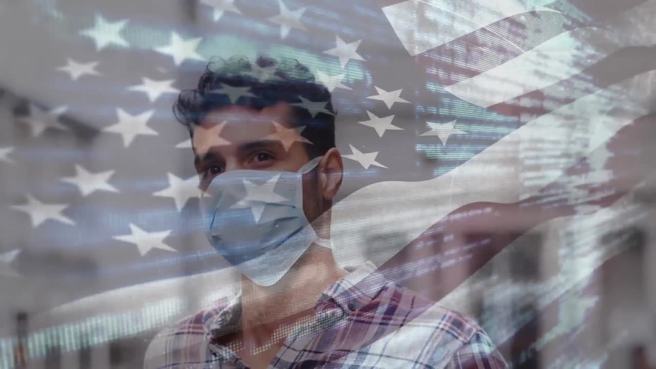 Animation of flag of usa waving over latin man wearing face mask in city street