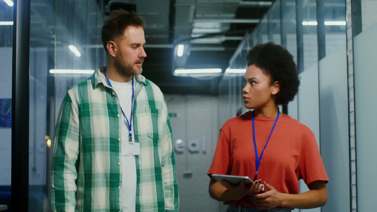 colegas de negocios discutiendo el proyecto en la tableta en el pasillo de la oficina