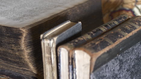 Close-up-pan-and-tilt-of-worn-ancient-books-with-map-in-background