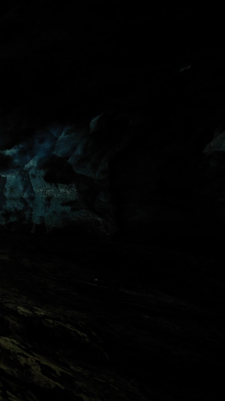 Exploring a dark cave with rocks and shadows during nighttime adventure