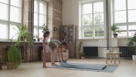 mother and daughter doing yoga at home