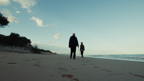 father and son walk together on the beach on father's day near the ocean