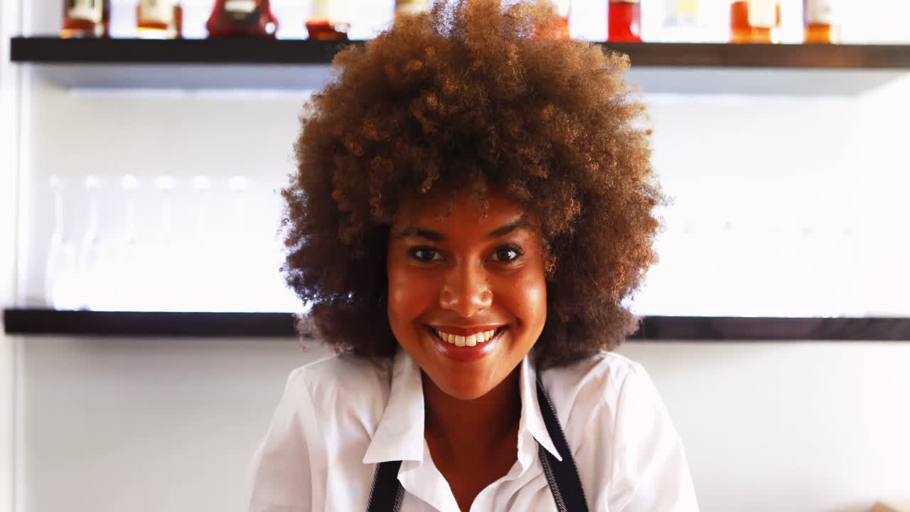 Portrait of confident waitress standing at counter