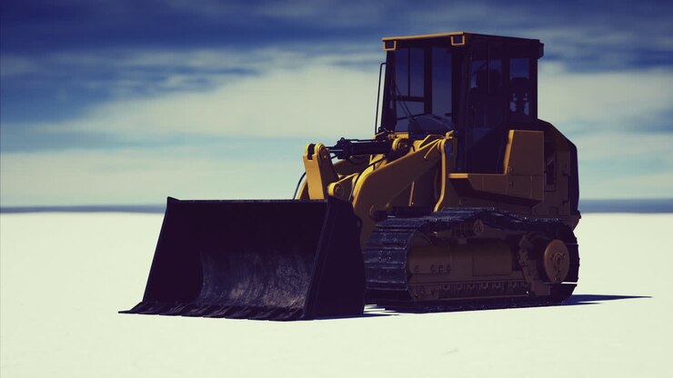Bulldozer on a snowy landscape creates tracks under a clear blue sky