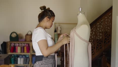 a woman creating a design with fabric on a mannequin in her workshop