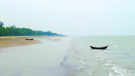 fishing boats at kuakata sea beach during sunrise in bangladesh, south asia
