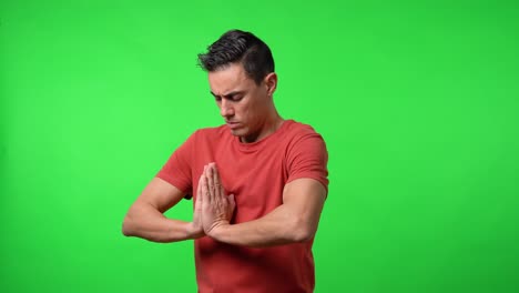 Man meditating with his eyes closed. Chroma green background.