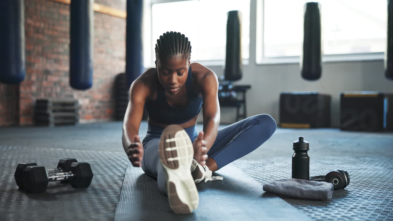 Fitness, gym and African woman stretching legs to