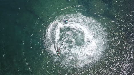 aerial shot, two jetsurf riders performing action maneuvers in ocean