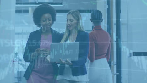 animation of financial data processing over diverse female colleagues using laptop in office