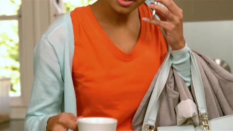 mujer bonita en una llamada telefónica sosteniendo una taza