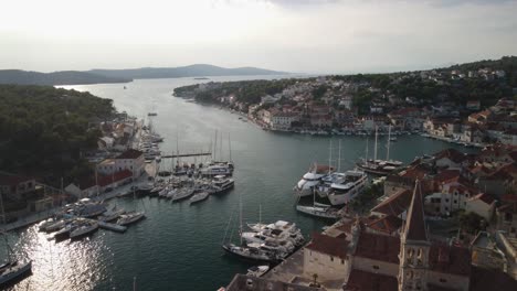 foto reveladora del hermoso puerto de milna, isla de brac, croacia, que muestra varios barcos clásicos junto con yates modernos y veleros