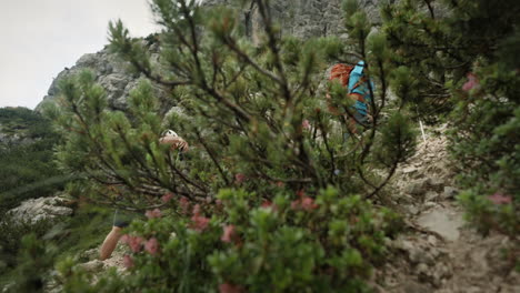 Hikers-wearing-bright-colored-clothes-and-helmets-climbing-up-a-mountain