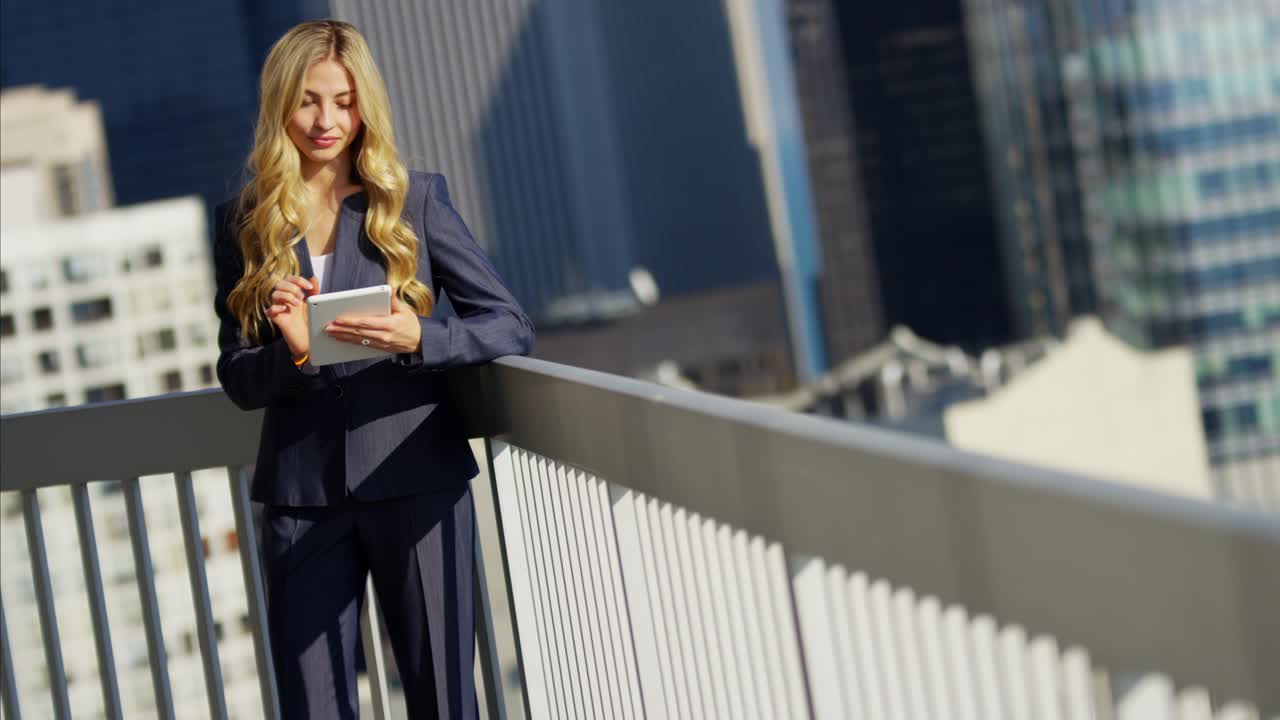 Caucasian American businesswoman using tablet technology on rooftop