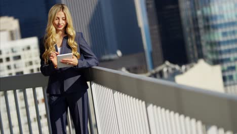 caucasian american businesswoman using tablet technology on rooftop