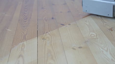 focused close-up of a sanding machine smoothing pine wood floors during a renovation project.