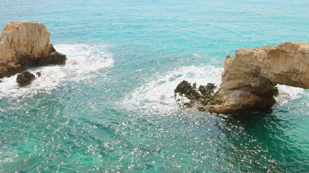 Stunning view of the natural rock formations, including the iconic Love Bridge arch, along the vibrant turquoise coast of Cyprus